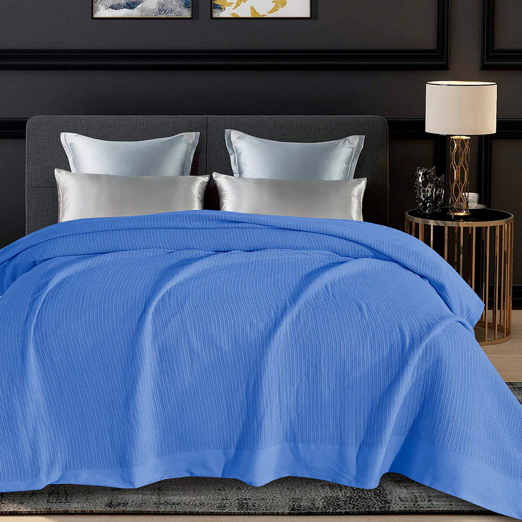 image of a bedroom having  blue color blanket on bed. 